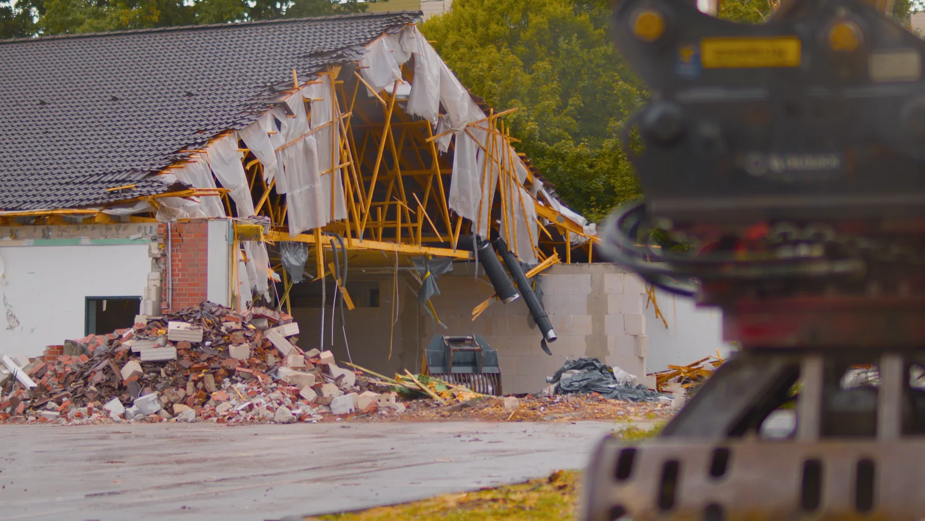 Gebäude beim kontrollierten Rückbau mit Baumaschine